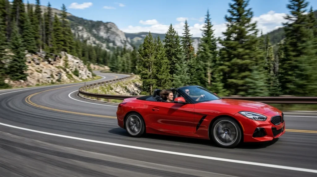 Red 2024 BMW Z4 sDrive30i driving down a curved mountain road on a sunny day