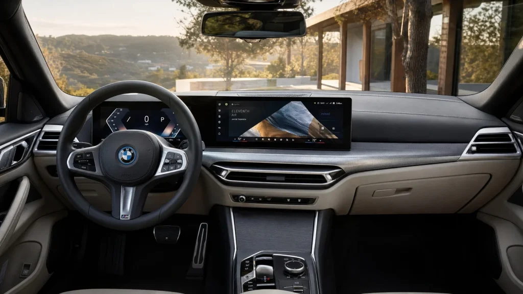 Close-up of the BMW curved glass display inside the 2025 BMW i4 showing the updated iDrive 8.5 menu.