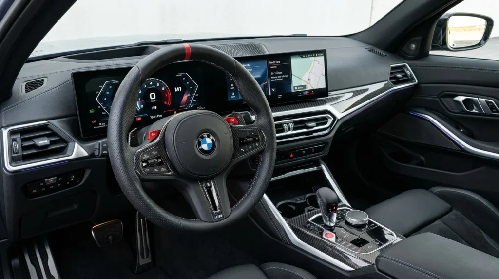 2025 BMW M3 Review: Price, Range, Performance 3 The refined cabin of the 2025 BMW M3 showing the curved display and updated flat-bottom steering wheel.